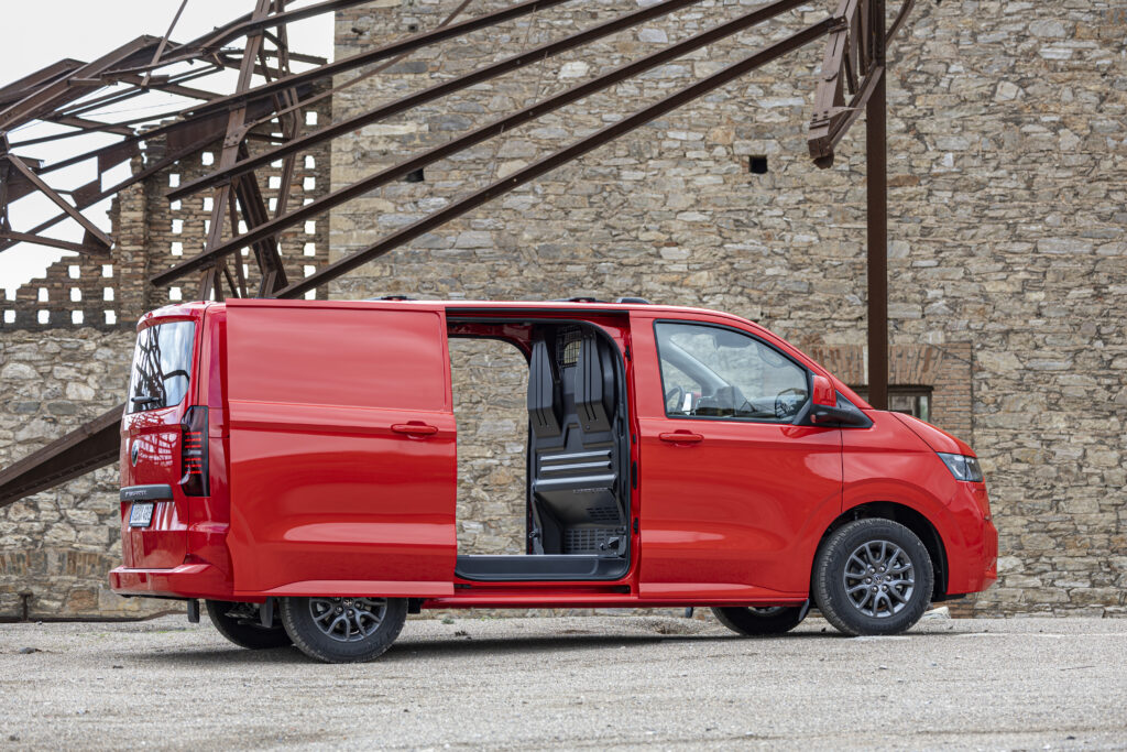 Otvorené bočné dvere na červenej panelovej dodávke Volkswagen Transporter